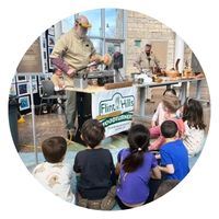 Group of children watching a man turn wood on a lathe